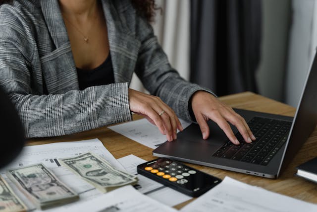woman-working-on-laptop-with-papers