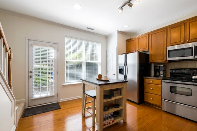 a-kitchen-with-warm-toned-wood-floors-and-cabinets.png