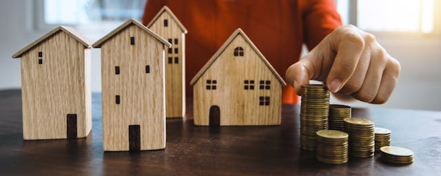 a-bunch-of-house-figurines-with-coins-next-to-them.png
