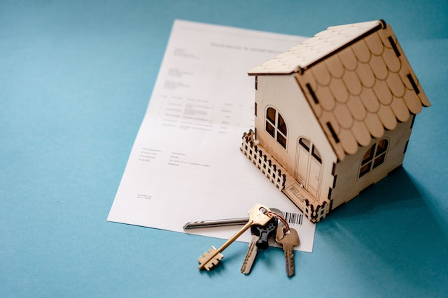 a-home-figurine-and-house-keys-resting-on-a-contract.png