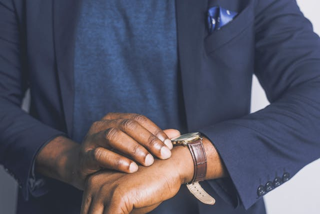 person-in-a-blue-suit-looking-at-their-watch.png