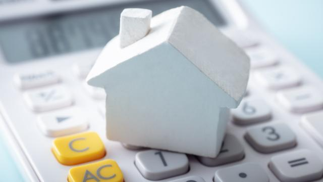 a-small-home-figurine-on-top-of-a-calculator.png