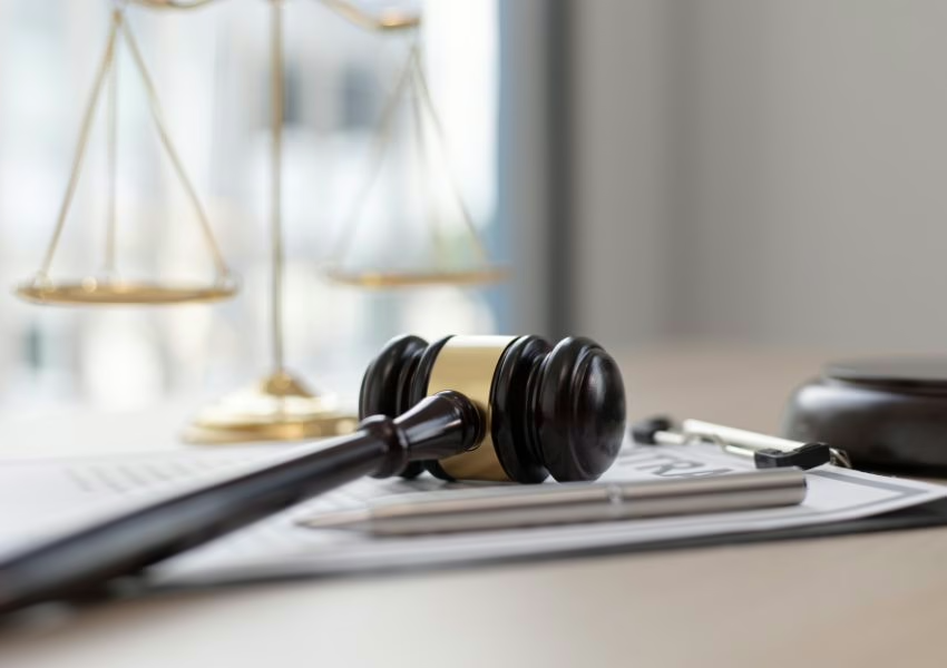 judges-gavel-on-top-of-a-clipboard-with-a-legal-balance-in-the-background.png